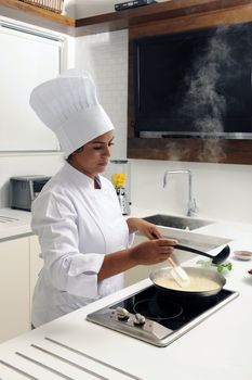 Chef cooking risotto adding stock and stirring