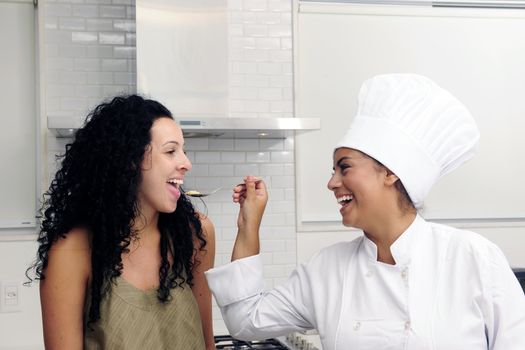 Cookery course: Chef offering his tasty risotto on a spoon for tasting