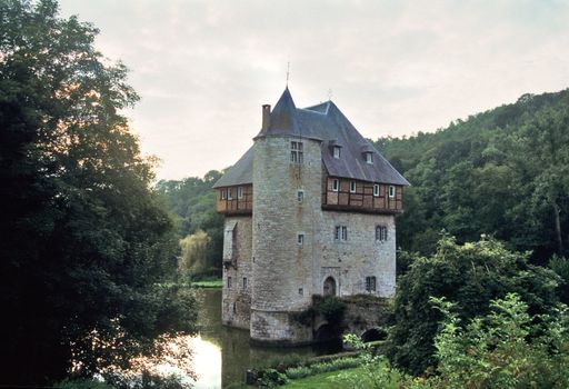 The sun sets on a castle surrounded by a moat in the Wallonian region of Belgium.