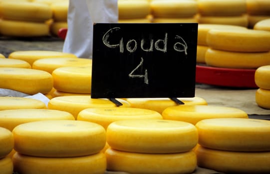 Stacks of Gouda cheese wheels wrapped in wax at the Alkmaar cheese market.