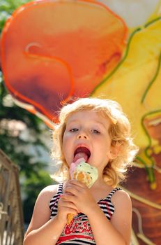 little girl outdoors eating huge ice cream cone