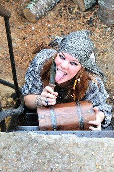 beautiful redheaded pirate girl is licking knife