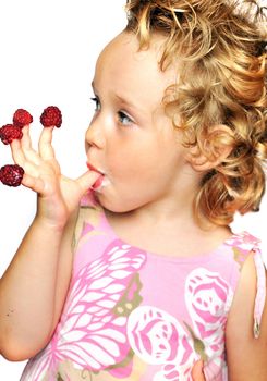 funny young girl enjoying a fresh raspberries stacking on her fingers