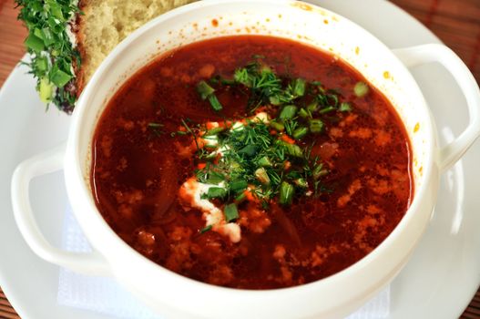 Ukrainian borsch with sour cream, russian donut  with garlic  in a white plate