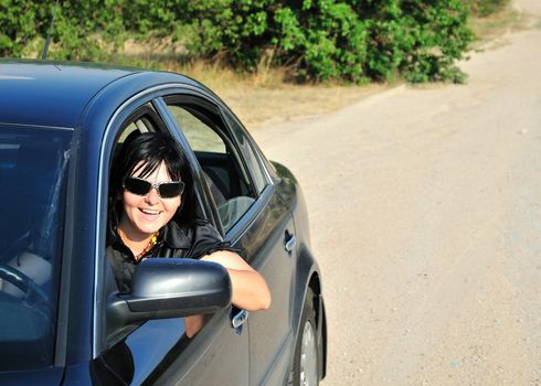 happy girl drive her car in the countryside,  she is happy, he smiling 