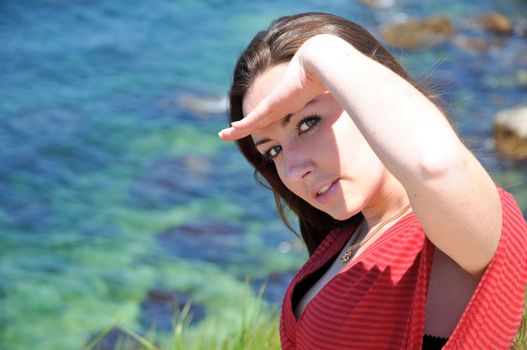 pretty brunette is looking at the camera over sea backgroung