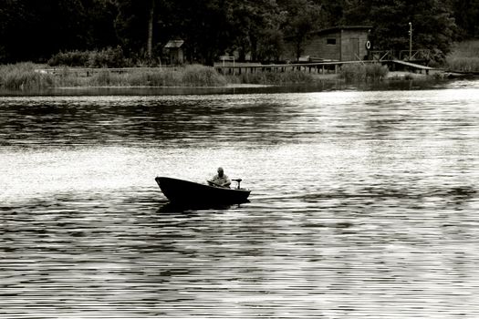 fisherman goes out fishing, wharf in background