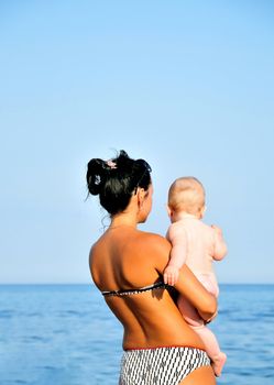 tanned mother showing  her  little baby Black sea 