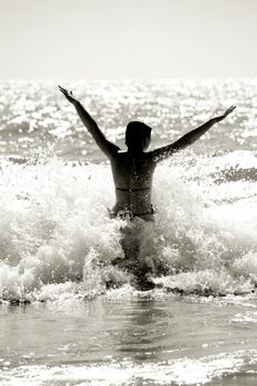 silhouette of a wet young woman in a waving sea