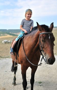 little boy is riding horse, it's his the first time!