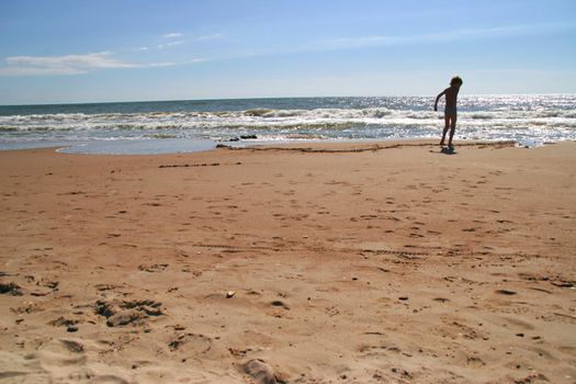 little boy plays on a seaside sand, Baltic sea, Latvia