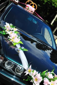  wedding car decorated with flowers and rings