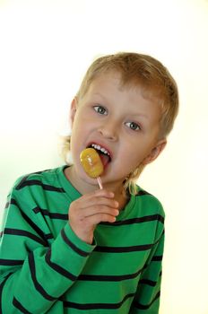 little boy  over white eating sweet  lollipop