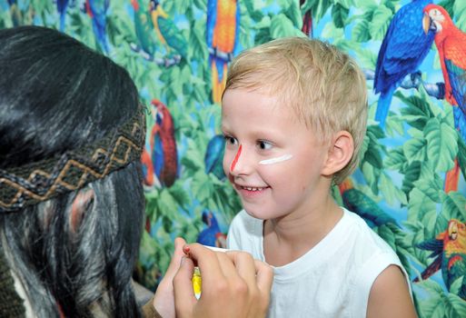 Indian painting panoply of paint on face of  little boy who has a birthday