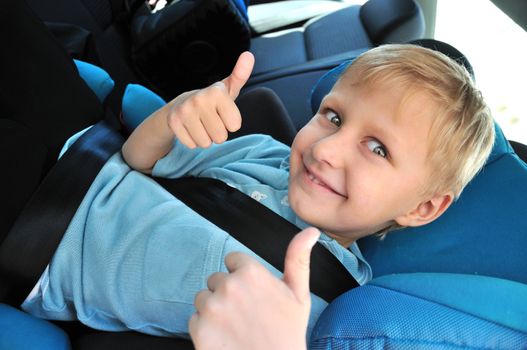 little schoolboy using child safety seat, he showing thumbs up