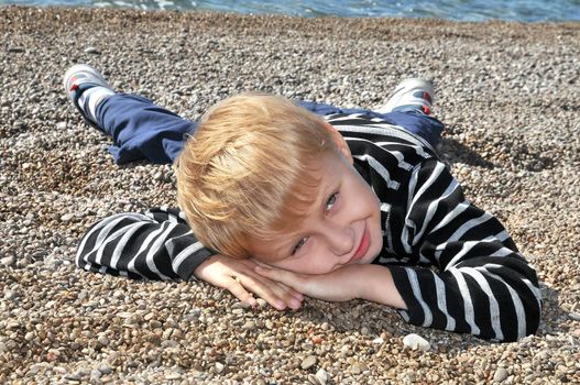 boy is laying at the beach in autumn time