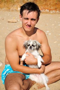 summer. beach. man holding little dog (Japanese Chin)