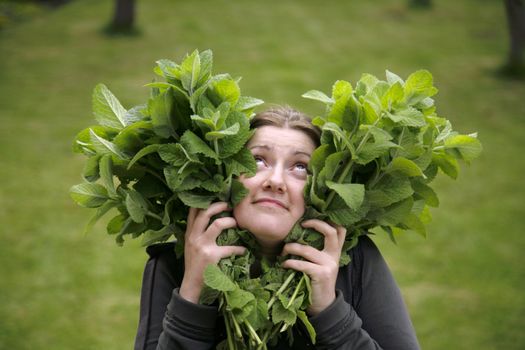 girl with heart shaped peppermint leaves in hands