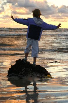 kid by the sea at sunset dreaming about sailing on a ship