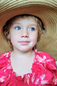 blue-eyed little  girl wearing  huge straw  hat