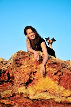 beautiful girl is laing on the top of cliff