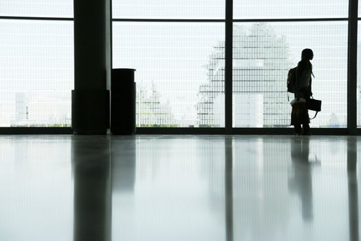 arriving in airport terminal, interior with girl silhouette 