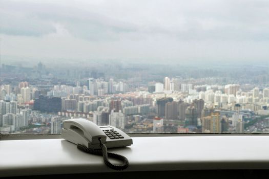 spectacular vista on growing real estate boom in Shanghai with telephone set on windowsill