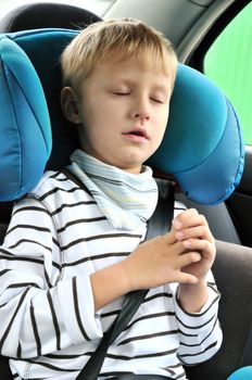 Young boy sleeping in the carseat

