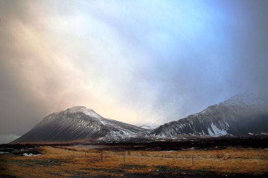 pastureland with rocky mountain in a overcast december day