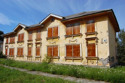 Spooky and grasy abandoned house with closed windows