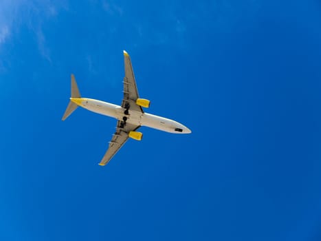 Landing airplane in the blue sky