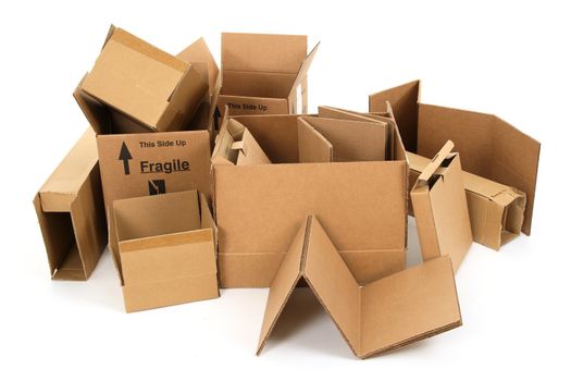 Pile of used cardboard boxes on white background.