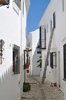 Narrow street with white houses and ladder