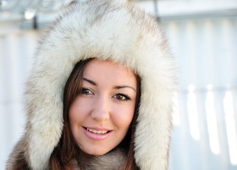 Pretty brunette with hazel eyes is wearing winter fur cap 