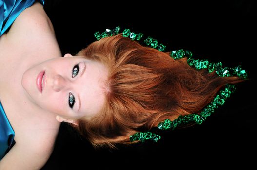 head of girl with natural red hair over black.