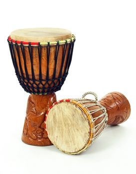 Two carved African djembe drums on white background.