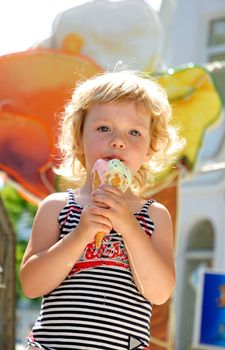 little girl outdoors eating huge ice cream cone
