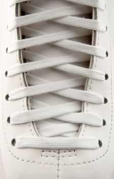 Closeup of a figure skate, showing laces in detail.