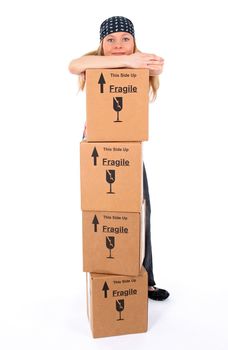 Girl standing behind a stack of cardboard boxes.