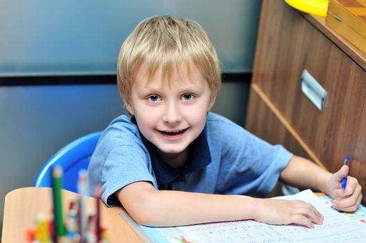  left-handed boy doing a home task in own room