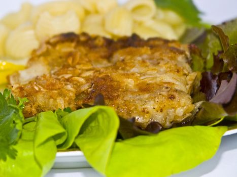 The image of macaroni of a fish and slices of a lemon close up