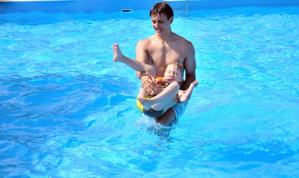 father and son having fun in water in summer time