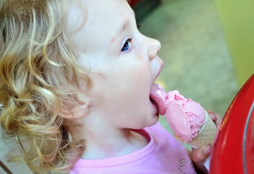 little girl outdoors eating huge ice cream cone 