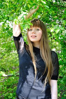 longhaired beautiful girl standing under the tree