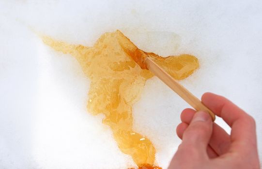 Maple taffy on snow, traditional treat in Quebec, Canada.