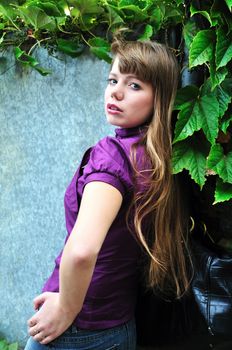 fashion girl wearing purple blouse near the wall
