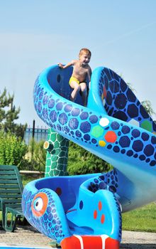 Cute little boy sliding down a water slide
