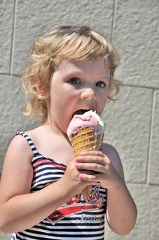 little girl outdoors eating huge ice cream cone

