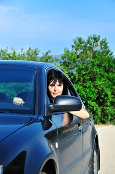 young brunette woman driving a car outdoors