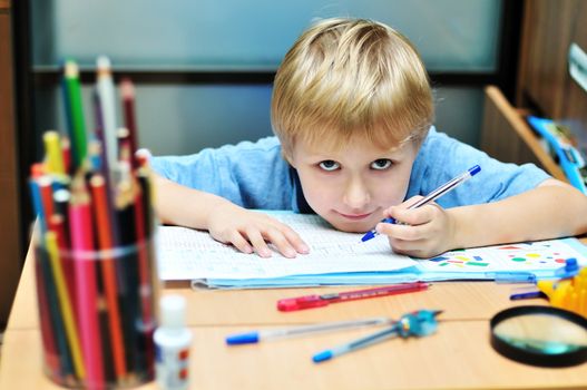 eft-handed boy doing a home task in own room
